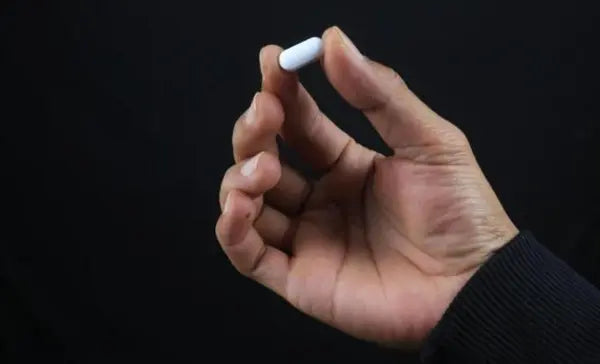 Man holding capsules